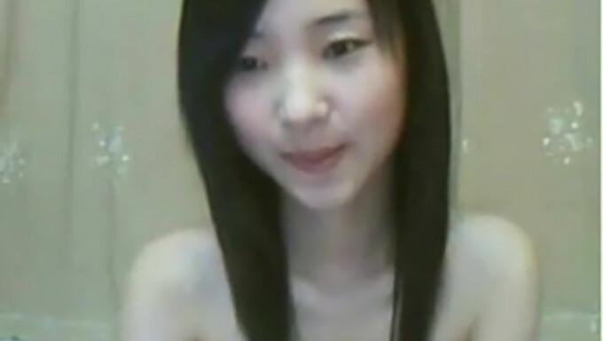 Una Joven Oriental Se Entrega Al Auto-Placer En La Webcam